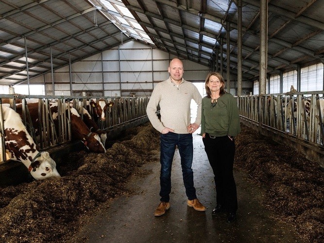 Erfcoaches Niek Oude Scholten en Yvonne in ’t Veld, staand in een koeienstal